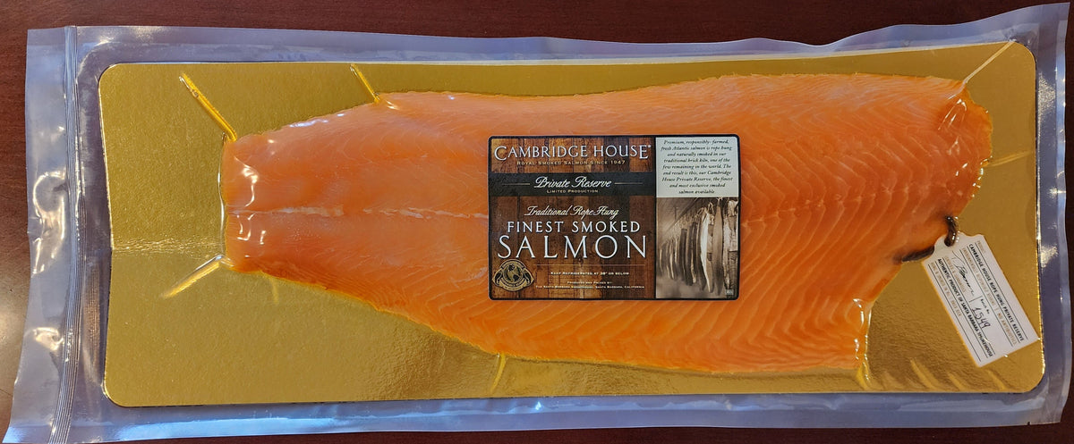 Packaged salmon fillet on a yellow cutting board with a label on a wooden surface